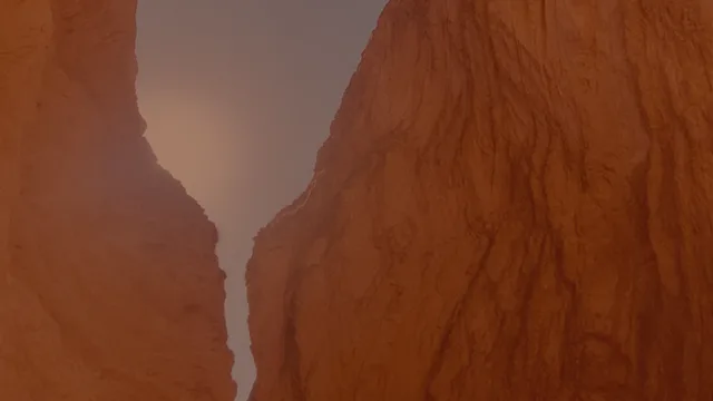 Looking up through a narrow gap between two steep orange-brown rock walls toward a hazy grey sky with a faint warm glow.